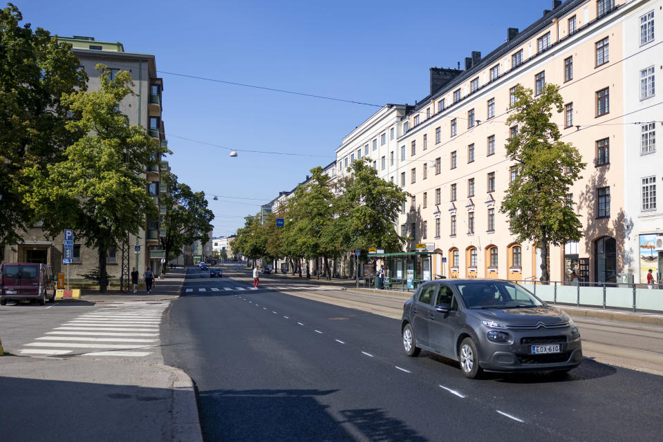 Auto, jalkakäytävä, suojateitä ja ratikkapysäkki Mannerheimintiellä  Linnankoskenkadun risteyksessä.