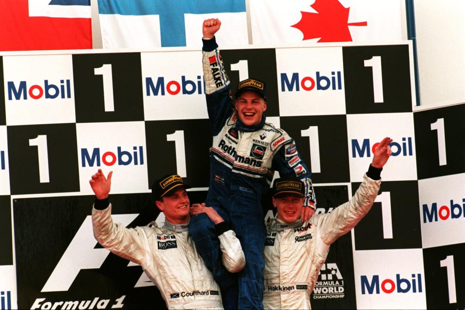 Villeneuve nousee kultatuoliin, jota kannattelevat McLarenin David Coulthard ja Mika Mäkkinen.