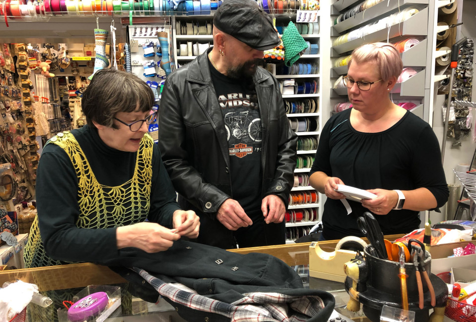 Helena Kaitila (vas) ja Tanja Pietilä pohtivat Kari Suomalaisen kanssa, mihin solkisomisteet kannattaisi paidassa kiinnittää. 