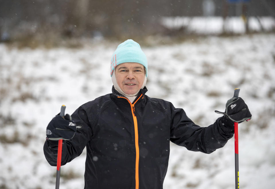 Jari Heikkinen katsoo kameraan hiihtovarusteissaan ladun vierellä