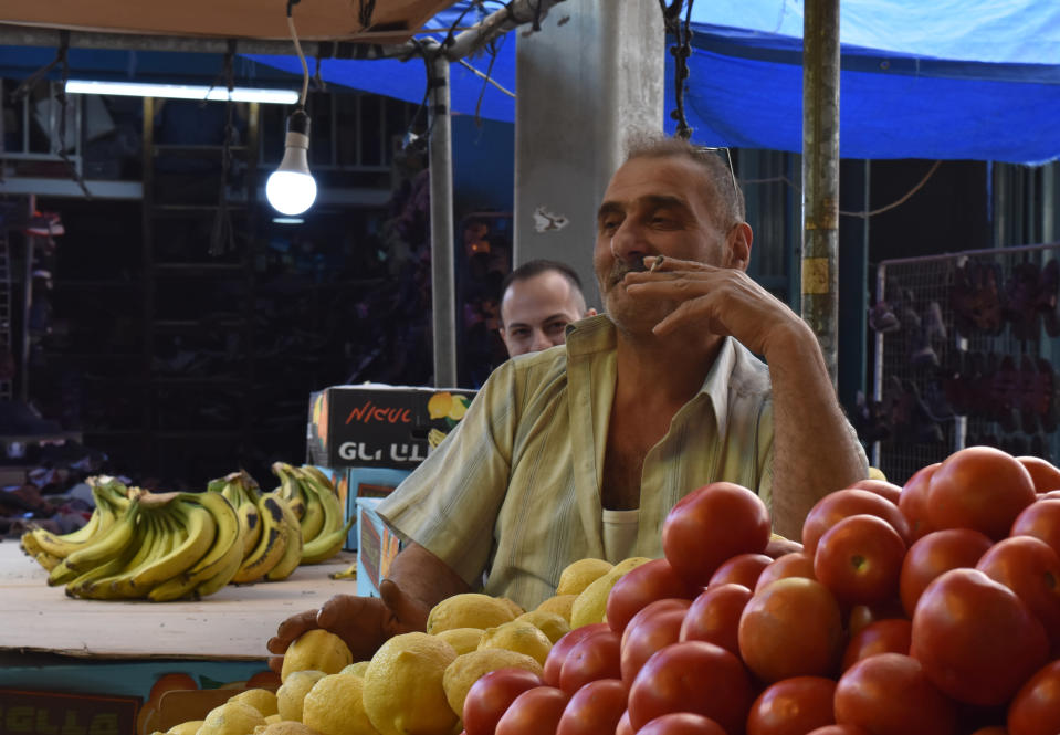 Kauppias Abu Gadab polttaa tupakkaa hedelmä- ja vihannestorilla Betlehemissä. 