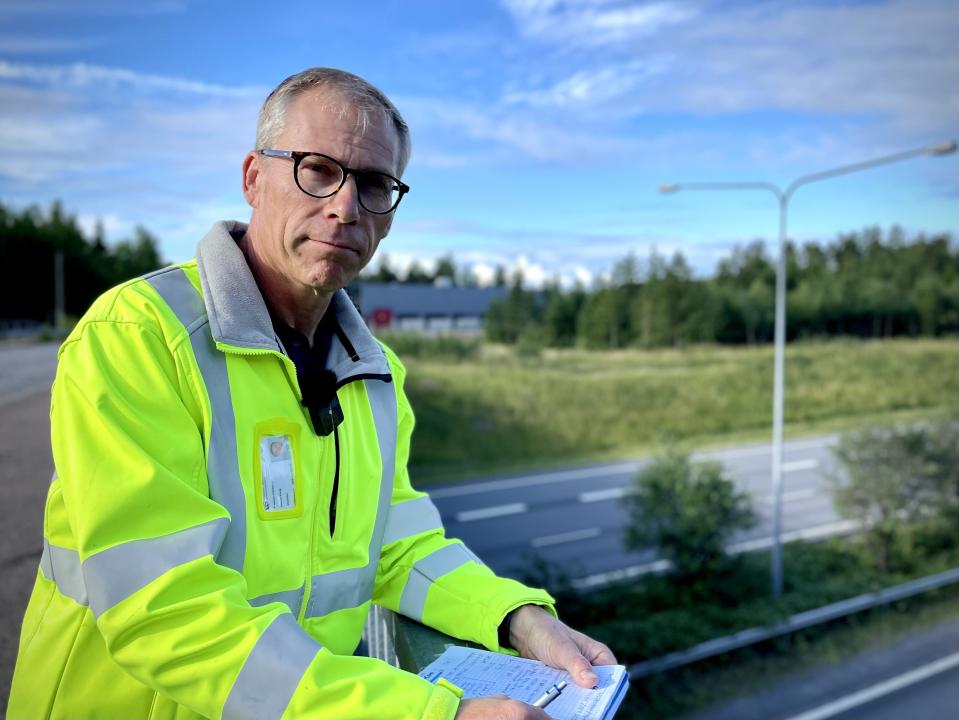 Ely-keskuksen liikenneturvallisuusinsinööri Jaakko Klanf nojaa kaiteeseen keltainen huomiotakki yllään.