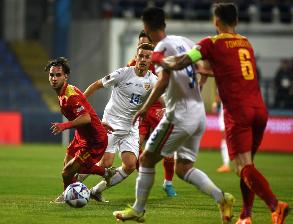 Montenegron ja Romanian pelaajat kamppailevat pallosta 4.6.2022. 