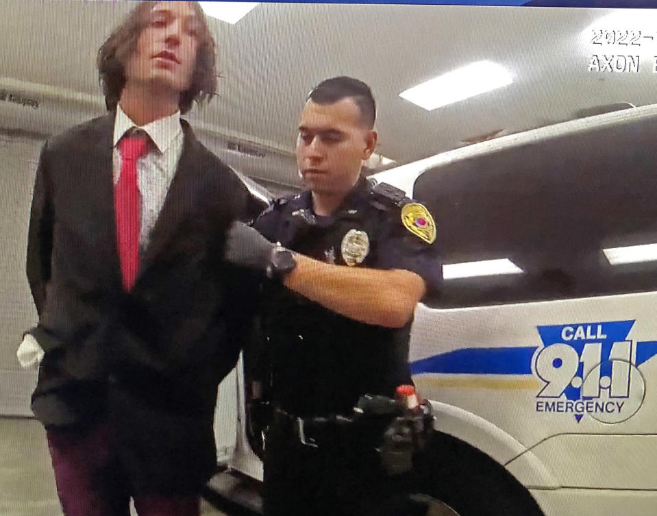 Ezra Miller poliisin otteessa kädet selän taakse kahlittuna.