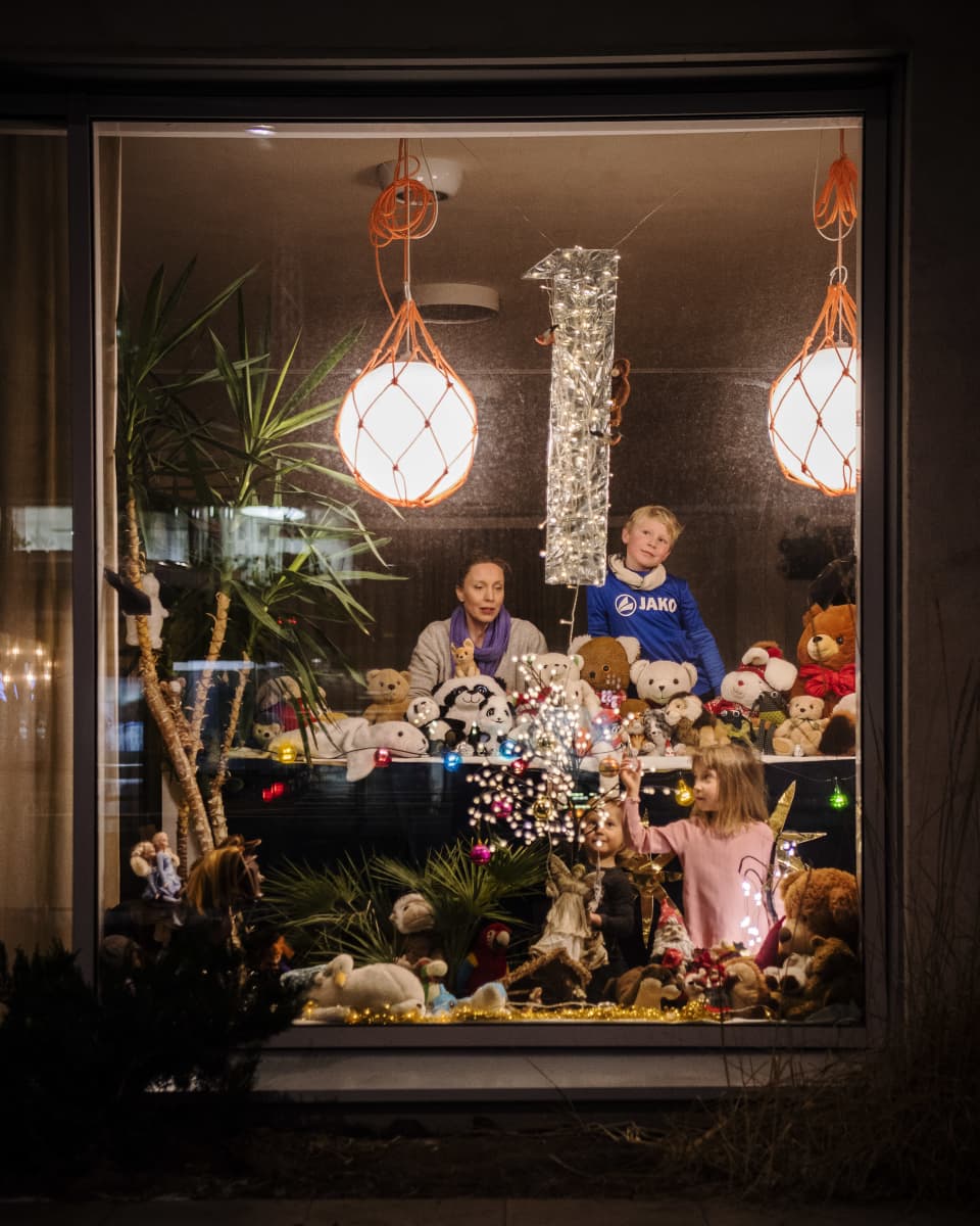 Riikka Haikarainen ja tyttäret Lahja ja Helle Jaskari sekä naapurin poika Samuel Pollock poseeraavat joulukalenterikkunassa.
