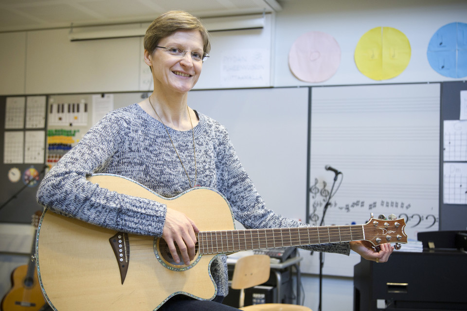 Musiikinopettaja Titta Lampela kitaran kanssa.
