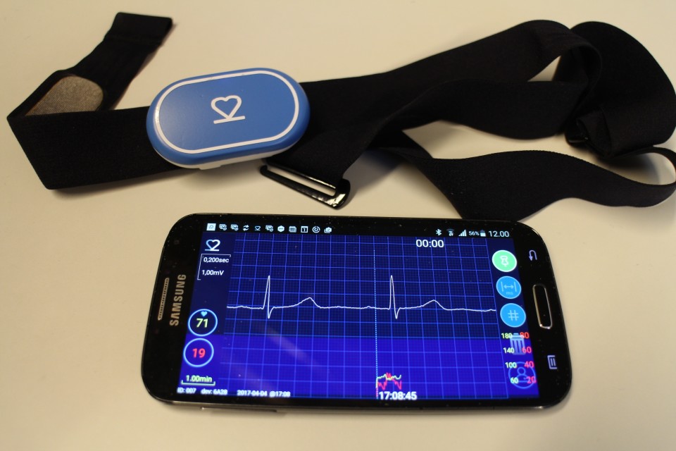 VTT:n kehittämä EKG-laite sykevyössä sekä älypuhelimen näytöllä sovelluksen välittämä kuva normaalista sydämen rytmistä. Valokuva Teija Peltoniemi.