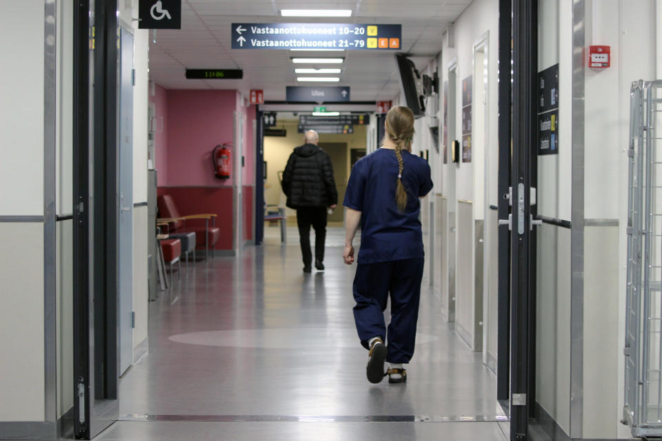 Sairaanhoitaja kävelee sairaalan käytävällä.