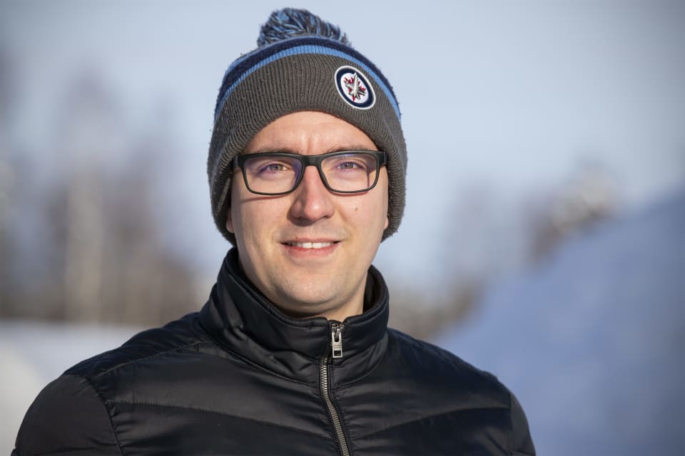 Jasmi Muqolli pipo päässään talvimaisemassa.