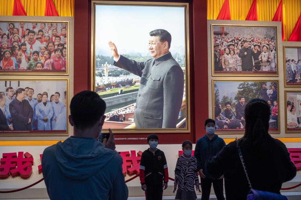 Joukko ihmisiä katsoo Xi Jinpingin kuvaa Kiinan kommunistisen puolueen museossa.
