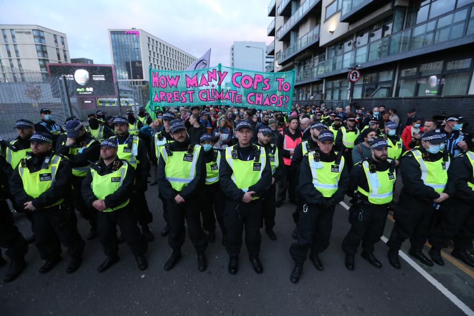 Glasgowissa mielenosoittajia oli tiistaina pitämässä kurissa iso joukko poliiseja. Kyltissä lukeekin: Montako poliisi tarvitaan pidättämään ilmastokaaos?