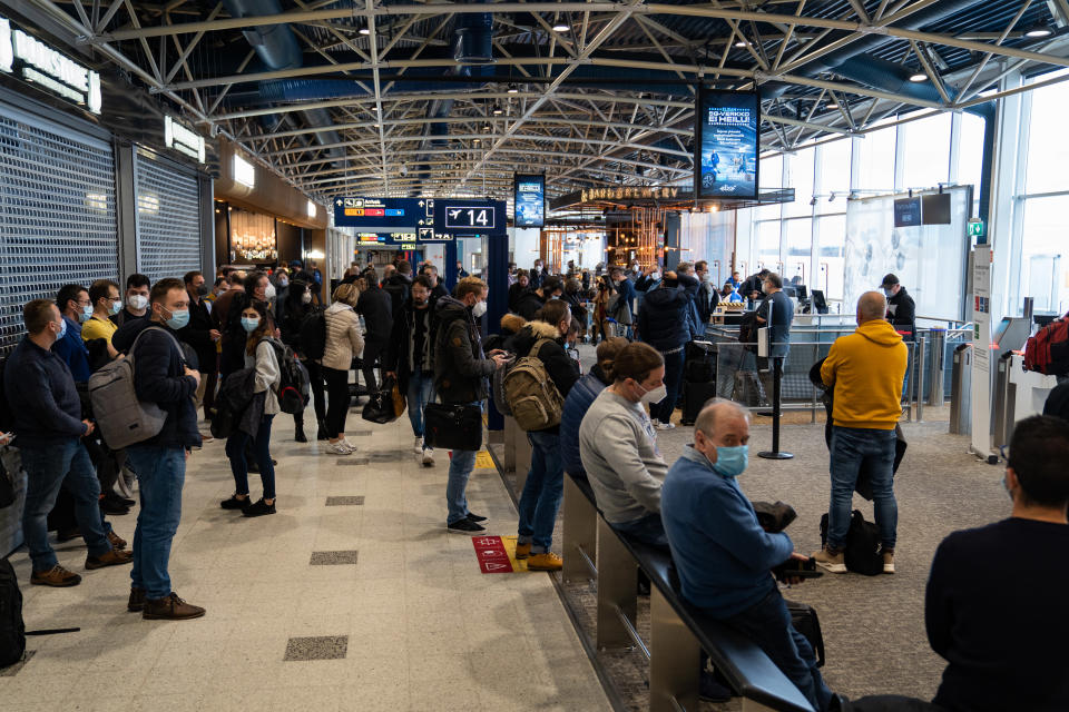 yleiskuva - ihmisvilinä Helsinki-Vantaan lentokentällä. Ihmiset odottavat pääsyä koneeseen.