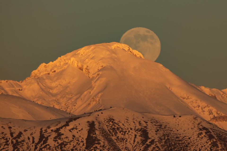 Kylmä kuu nousee auringonlaskun aikaan Monte Camicia -vuoren takaa Gran Sasson kansallispuistossa Italiassa.