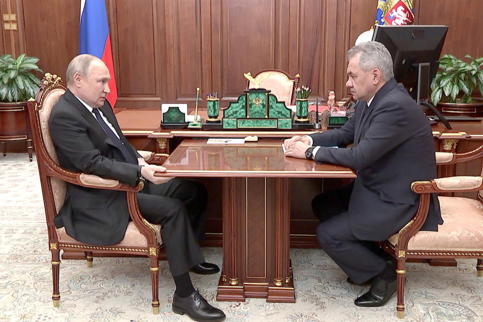 Vladimir Putin ja Sergei Šoigu keskustelevat pöydän ääressä.