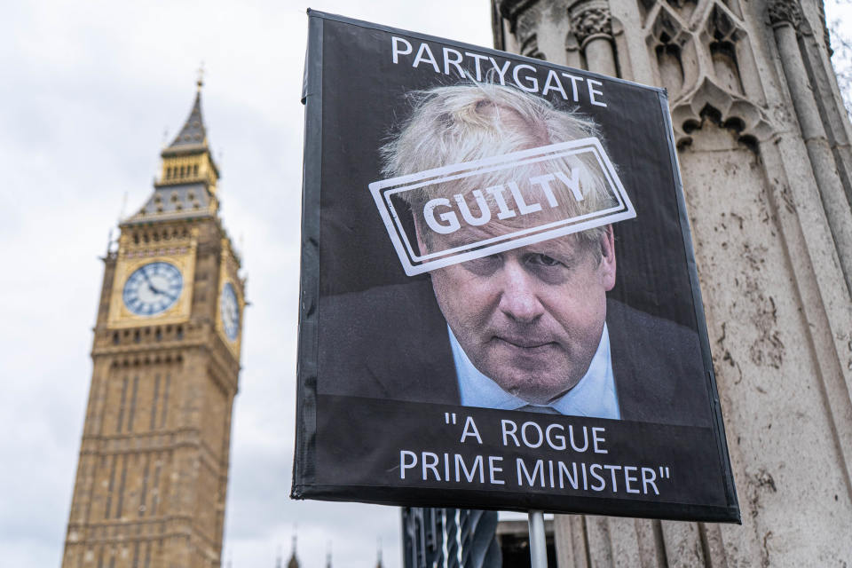 Boris Johnsonin kasvot mielenosoittajan kyltissä, Big Benin ulkopuolella Lontoossa. 