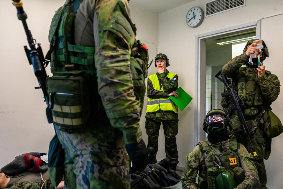 Annukka Ylivaara seuraa sotilaita sotaharjoituksessa.