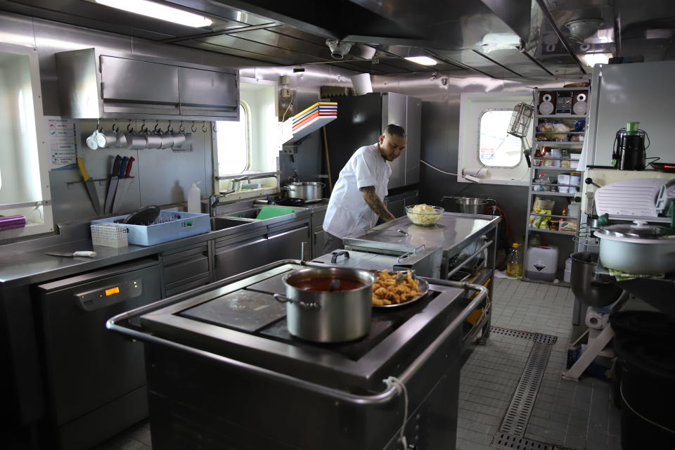 Rahtialuksen kokki työssään laivan keittiössä.