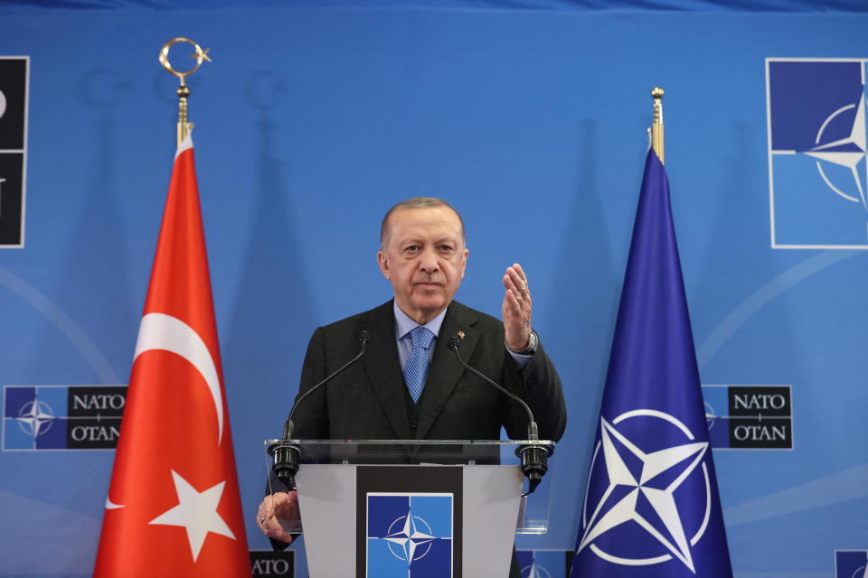 Turkin presidentti Recep Tayyip Erdoğan puhuu Naton päämajassa Brysselissä maaliskuun huippukokouksen jälkeen takanaan Turkin ja Naton liput.
