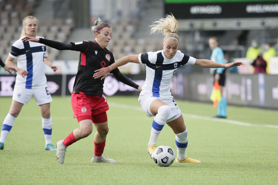 Suomen Emma Koivisto ohittaa pallon kanssa Georgian Irina Khaburdzanian jalkapallon MM-karsintaottelussa Suomi-Georgia. Ottelu Helsingissä 12. huhtikuuta 2022.