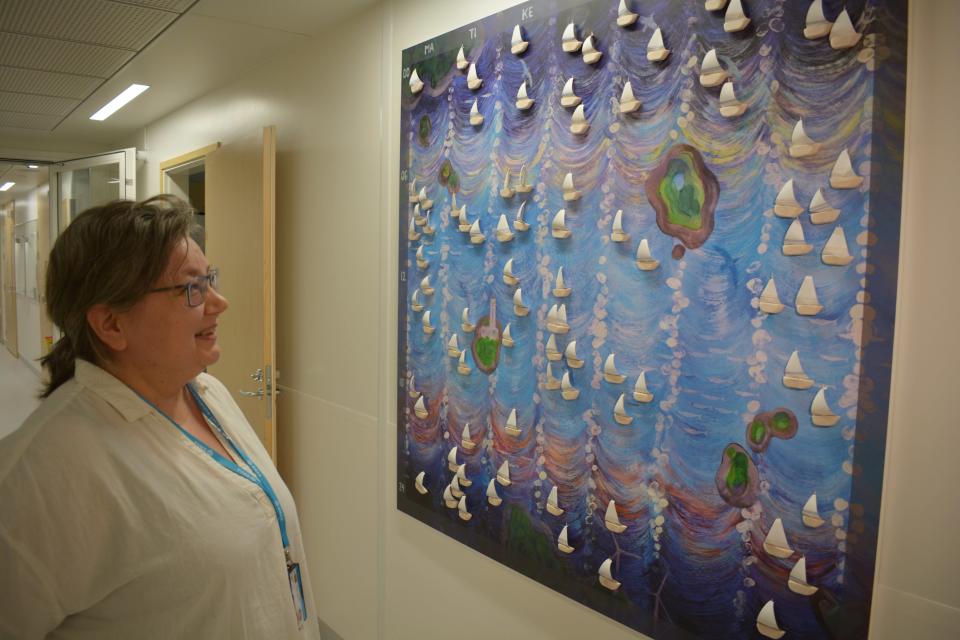 TYKSin naistenklinikan ylihoitaja Leila Varakas katsoo taulua, jossa on pieniä purjeveneitä. Jokainen vauva saa oman purjeveneen..