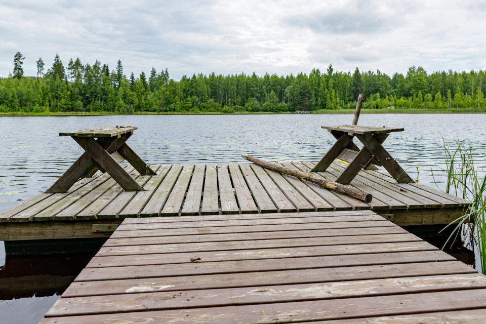 Laituri jolla kaksi penkkiä. Vastarannalla näkyy vihreää metsää.