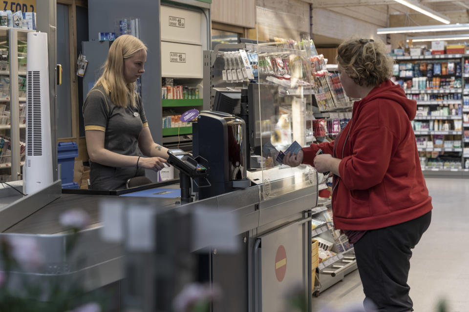 Nora Hoigari  COOP Varangerbotnin kassalla asiakkaan kanssa.