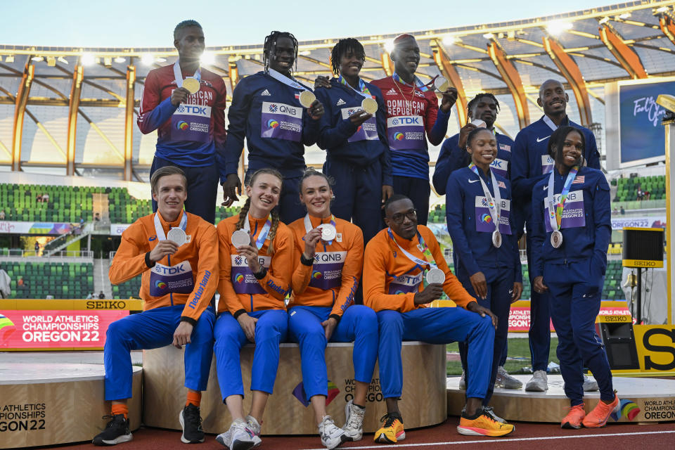 4x400 metrin sekaviestin MM-mitalistit poseeraavat palkintokorokkeella. Korkeimmalla Dominikaanisen tasavallan joukkue, jonka eteen hopealle sijoittunut Hollannin joukkue istuu. Oikeassa reunassa pronssia voittanut Yhdysvaltain joukkue.
