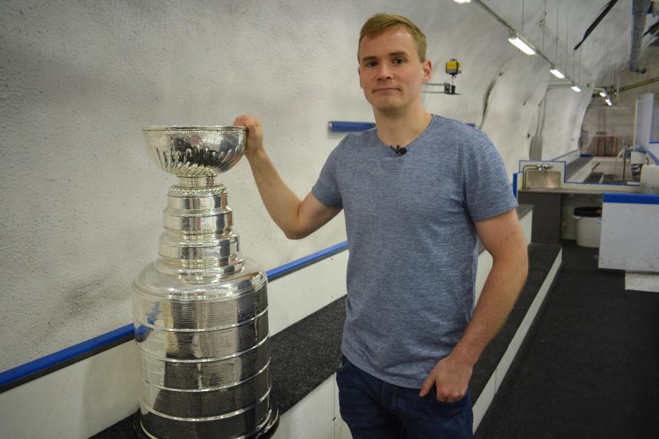 Artturi Lehkonen seisoo Stanley Cup -pokaalin vieressä Varissuon jäähallissa.