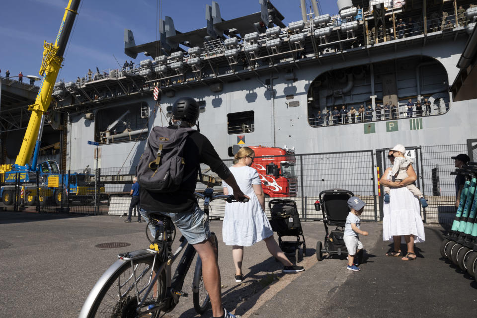 Ihmiset ihmettelevät USS Kearsarge sota-alusta Hernesaaren satamassa.