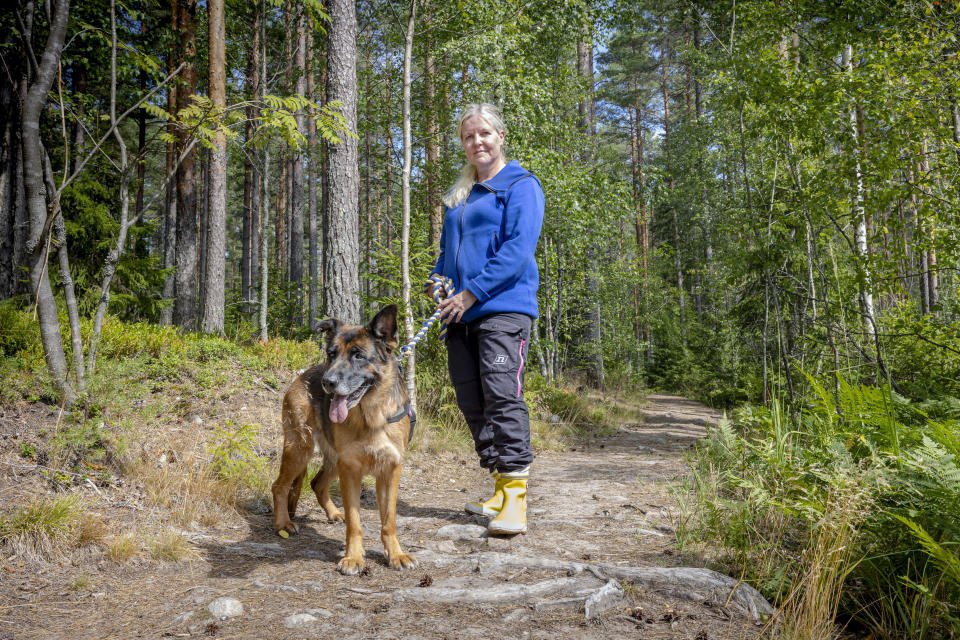 Nainen (Tanja Kammarback-Rossi Karjaalta) on koiransa kanssa metsäpolulla.