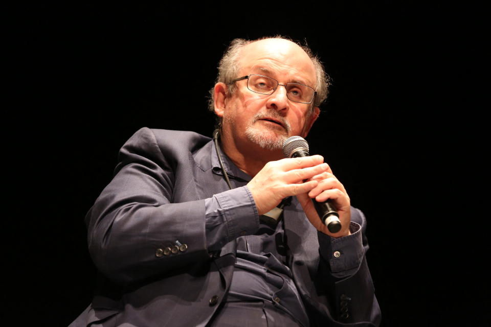 Salman Rushdie puhuu mikrofoniin.