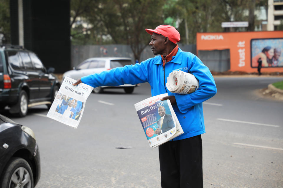 Ihminen jakaa lehtiä kadunkulmassa.