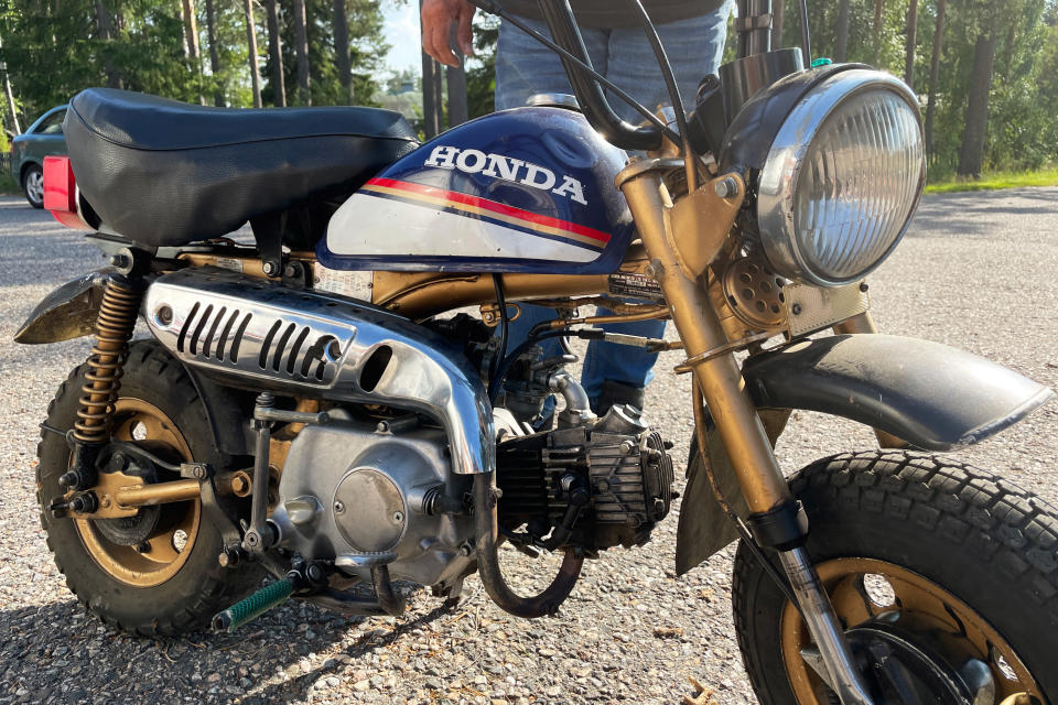 Honda Monkey (Z50J) -merkkinen mopedi, taustalla näkyy farkkuasuisen miehen jalat.