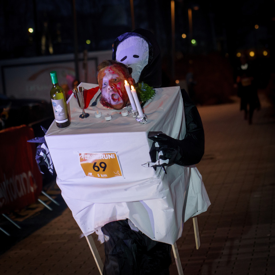 Halloween-juhlapöydäksi pukeutunt mies saapuu maalin Halloween Run-tapahumassa