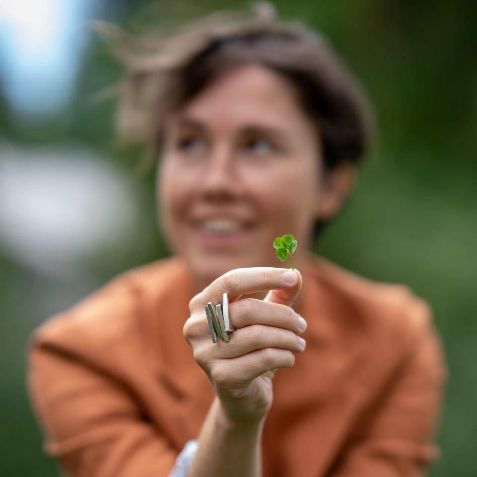 Amerikkalainen säveltäjä, laulaja ja viulisti Caroline Shaw kuvattuna Kallio-Kuninkalan pihalla Järvenpäässä 27.7.2022, kädessään hänen löytävänsä neliapila.